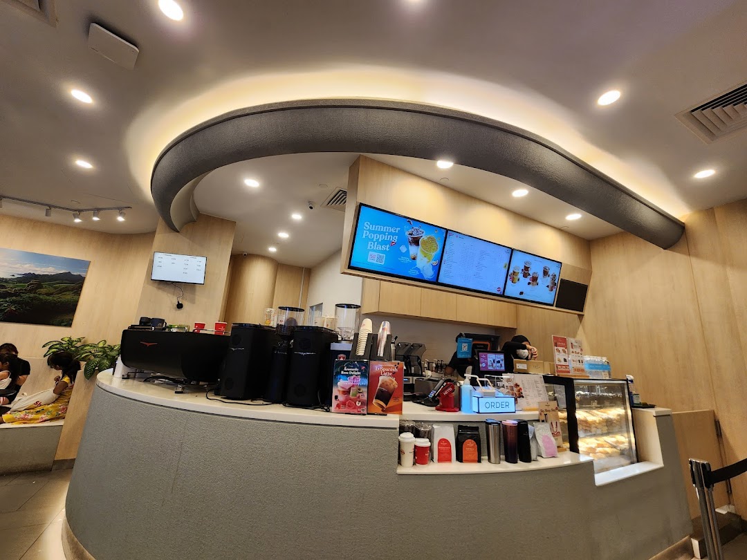 Interior view of Kenangan Coffee, featuring the service counter, digital menu boards, and a cozy seating area.