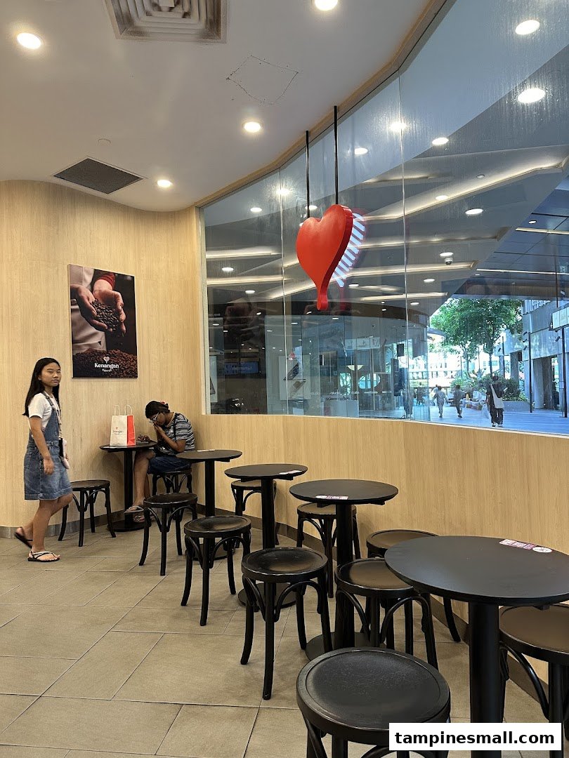 Interior view of Kenangan Coffee showing the seating area and large window.