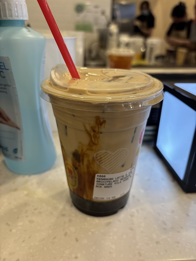 A refreshing iced coffee drink with a red straw, showcasing Kenangan Coffee's delicious beverages.