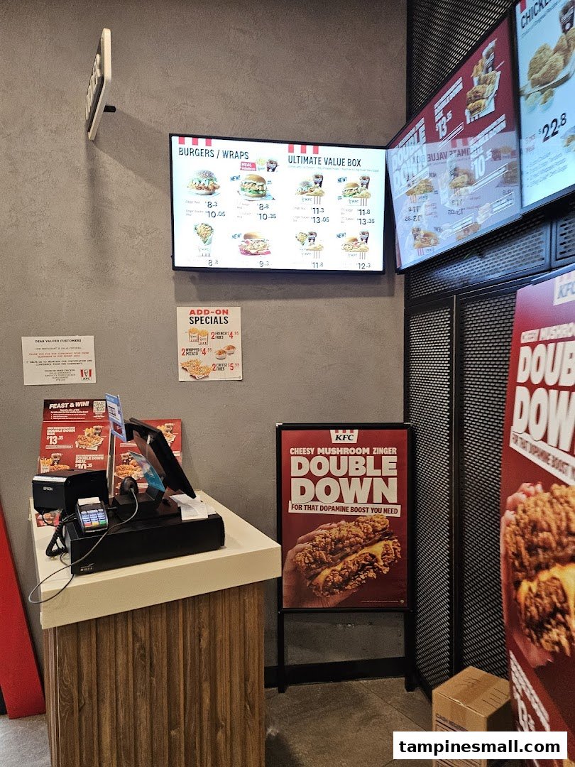 Interior view of KFC featuring digital menu boards, a service counter, and promotional signage.