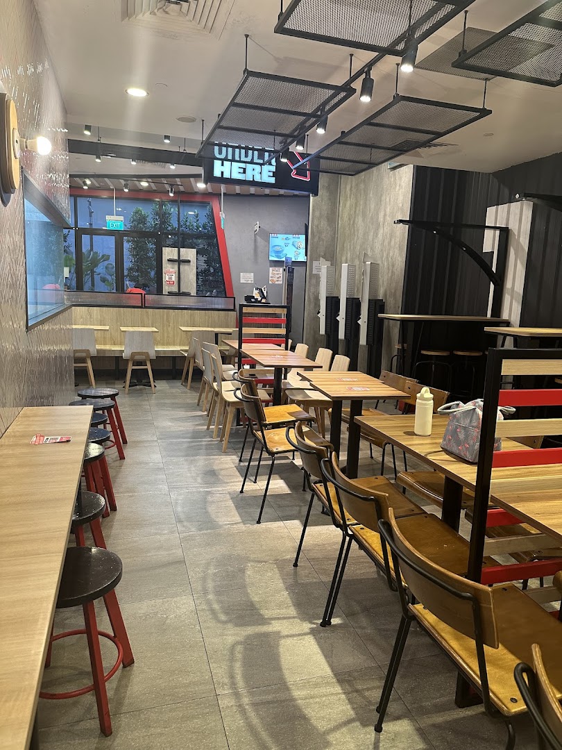 A view of the modern and spacious dining area inside a KFC restaurant, featuring various seating options.