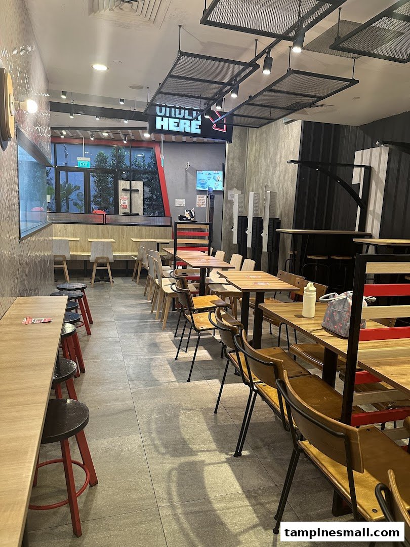 A view of the modern and spacious dining area inside a KFC restaurant, featuring various seating options.