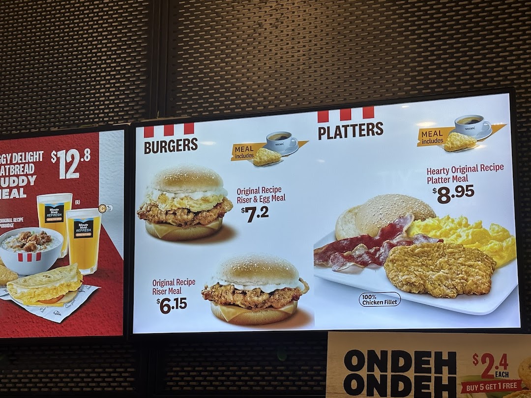 A digital menu board at KFC displaying various meal options, including burgers, platters, and breakfast items.