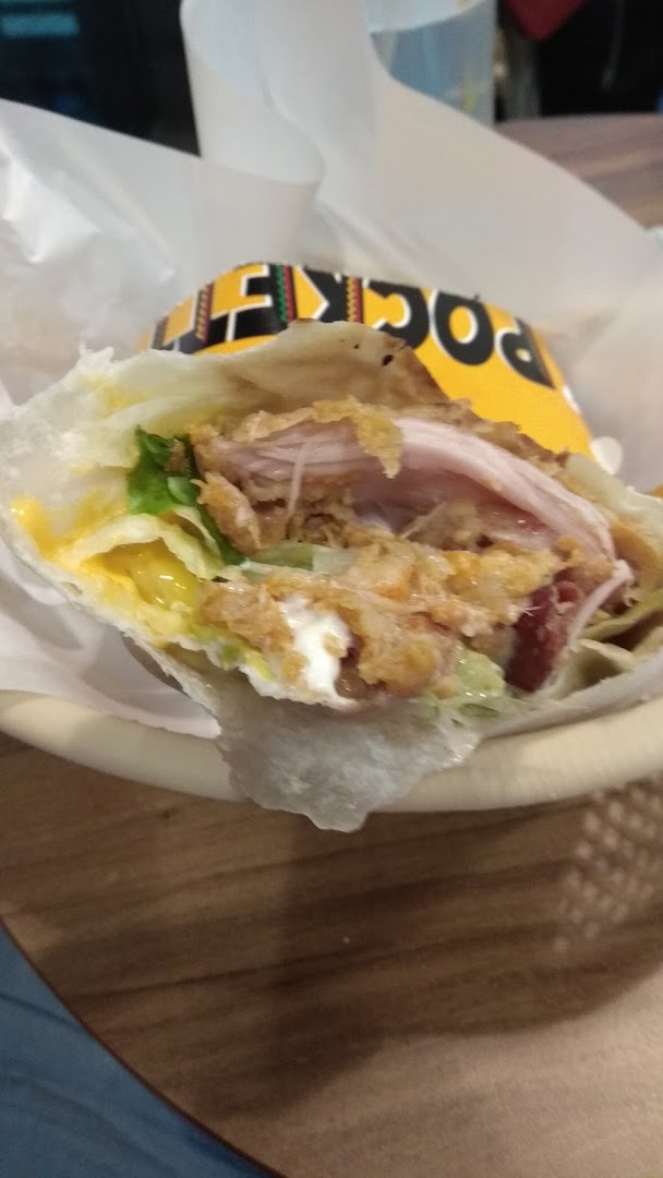 A close-up of a delicious KFC wrap, featuring crispy chicken, fresh lettuce, and creamy sauce.