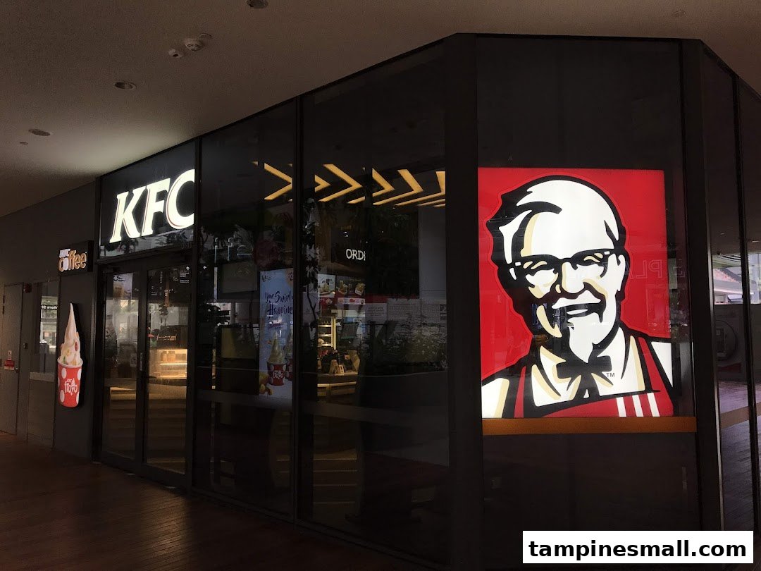 The illuminated KFC storefront features its iconic logo and a large Colonel Sanders graphic.