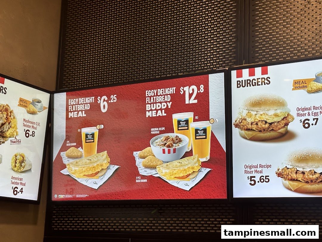 A brightly lit KFC menu board displaying breakfast and burger options with prices.