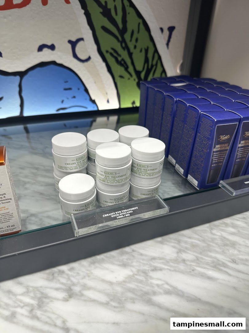 Close-up of Kiehl's Creamy Eye Treatment with Avocado and other skincare products on display.