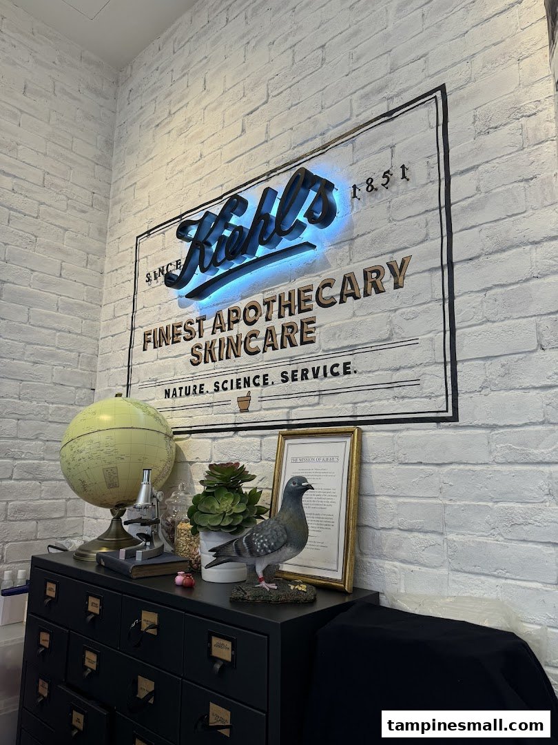 A Kiehl's branded wall featuring a neon sign, globe, and apothecary-style decor.