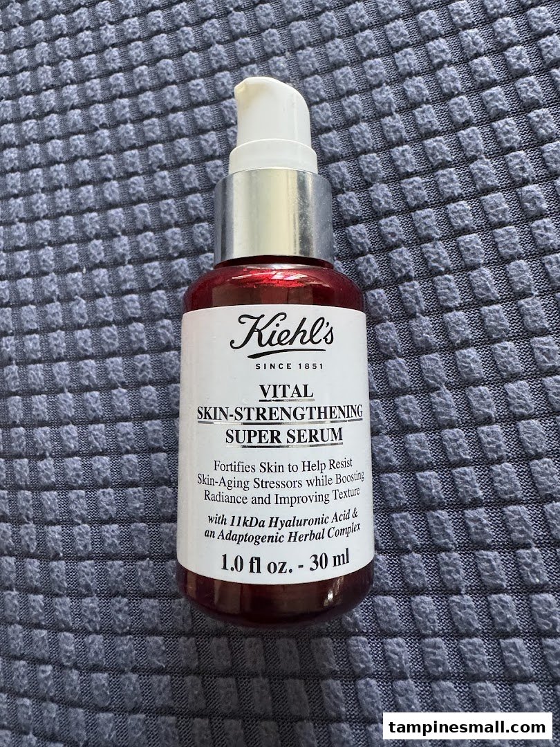 A Kiehl's Vital Skin-Strengthening Super Serum bottle on a textured surface.