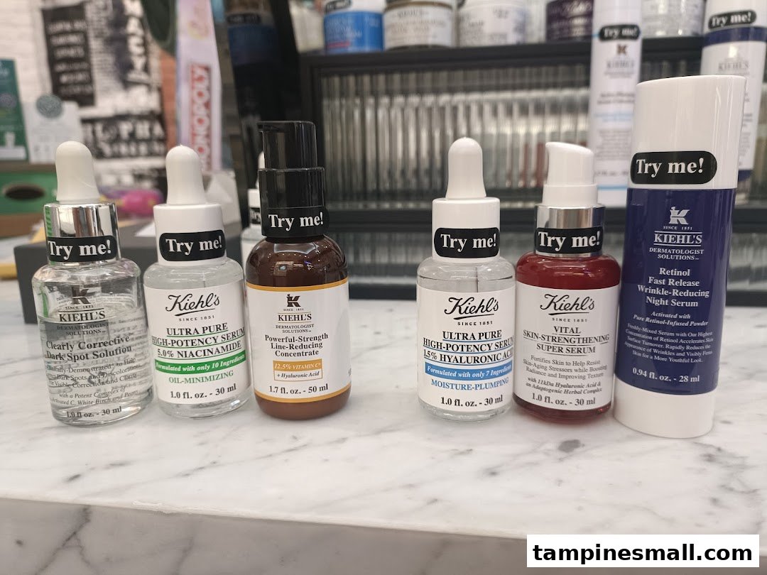 A close-up of various Kiehl's skincare serums and concentrates with 'Try me!' labels.