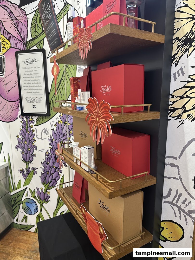 A Kiehl's display shelf showcasing skincare products and festive gift boxes with decorative elements.