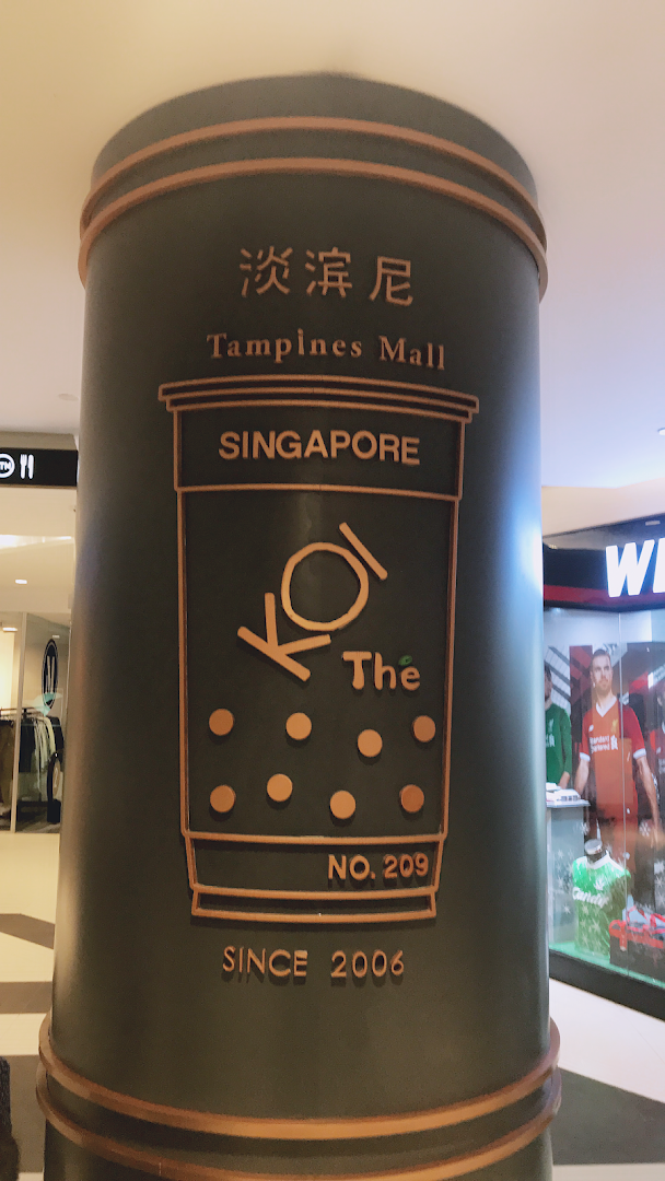 A decorative pillar featuring the KOI Thé logo, Tampines Mall name, and 'Since 2006' text.
