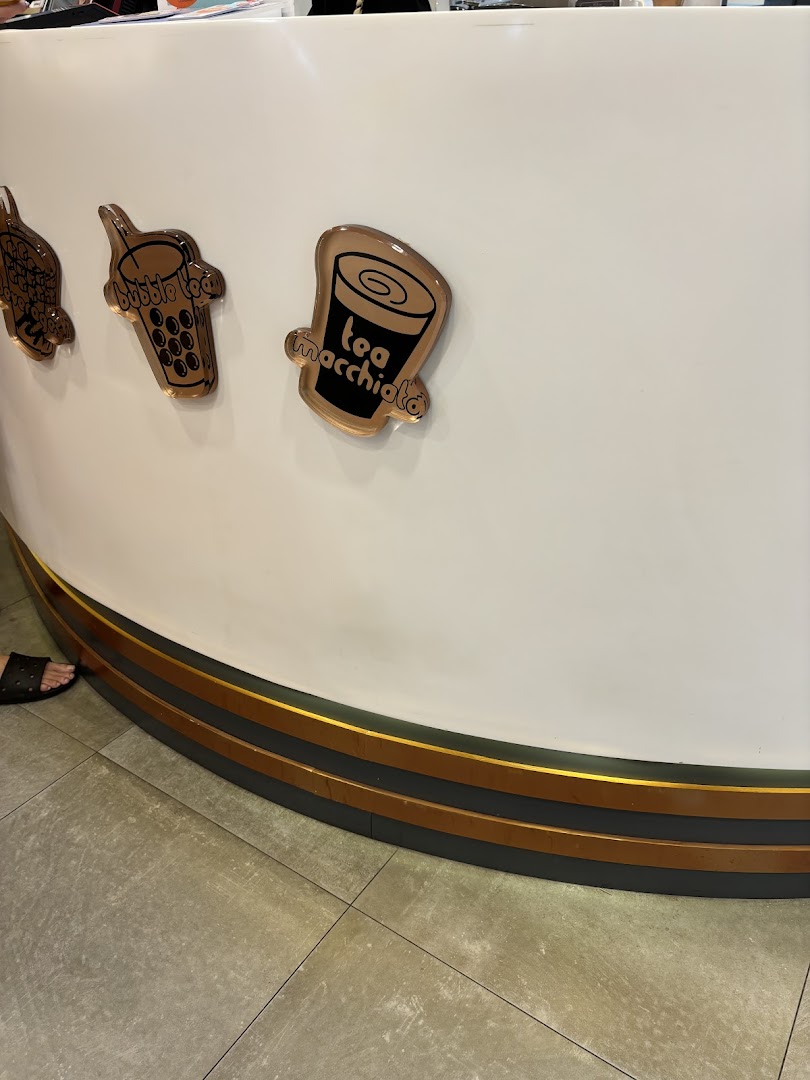 Close-up of KOI Thé counter featuring decorative icons for bubble tea and tea macchiato.