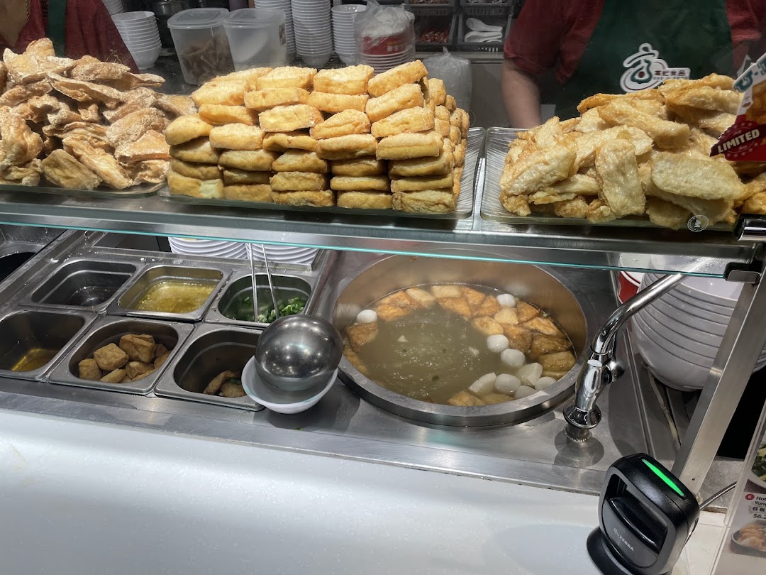 A close-up view of Koo Kee Yong Tow Foo Mee's counter, showcasing fresh ingredients and a simmering pot of soup.