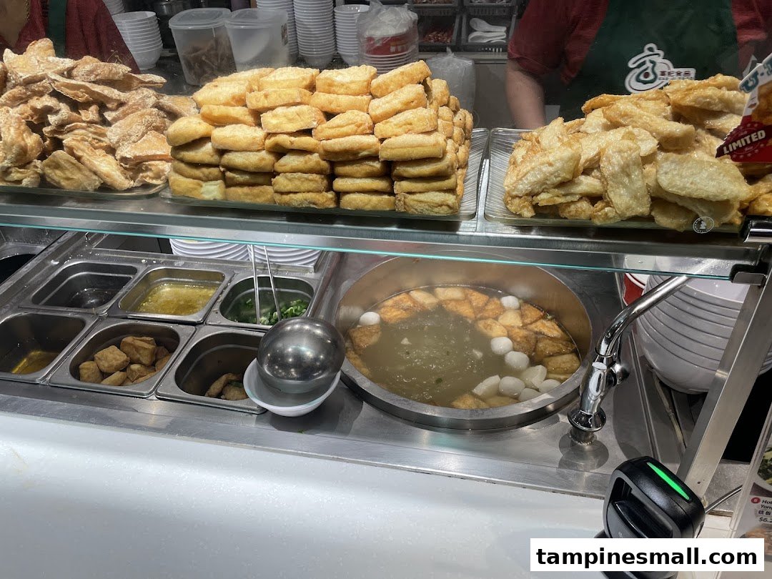 A close-up view of Koo Kee Yong Tow Foo Mee's counter, showcasing fresh ingredients and a simmering pot of soup.