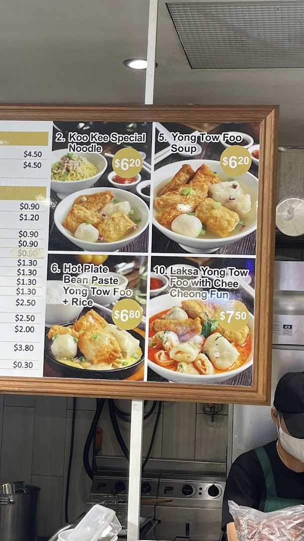 A vibrant menu board displaying various Yong Tow Foo dishes with prices and images.