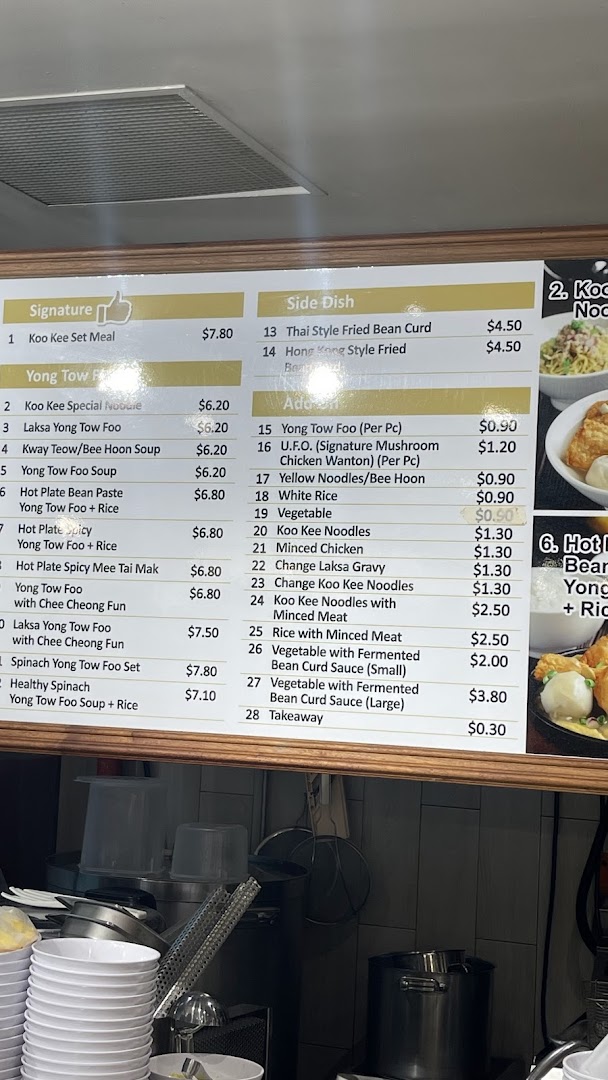 A detailed menu board displaying various Yong Tow Foo dishes and side orders with prices.