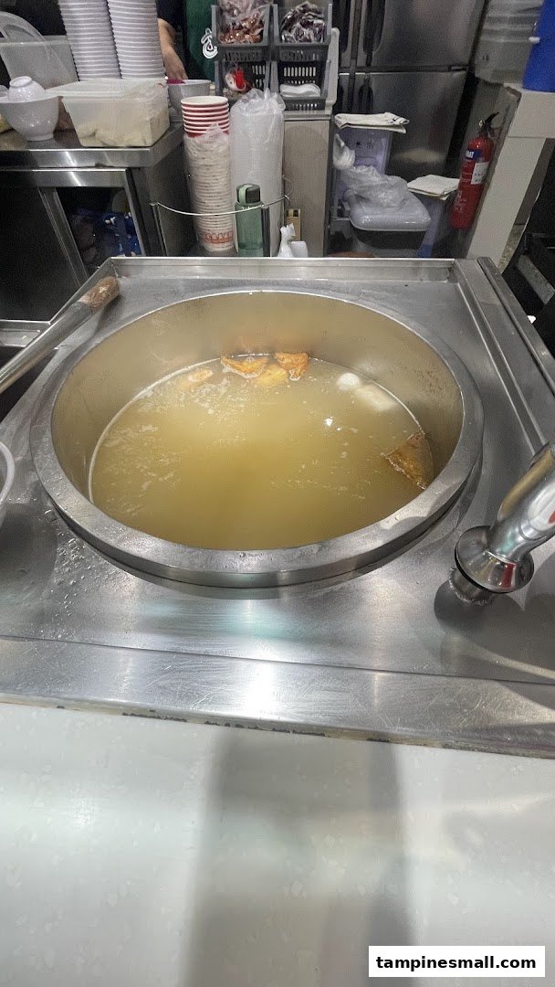 A large pot of simmering broth with ingredients, ready for serving.