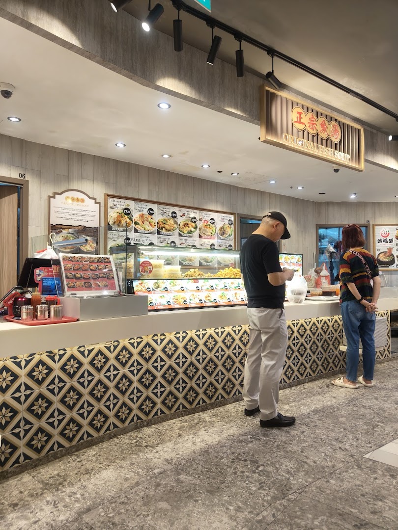 Customers at a food stall counter featuring a display of various dishes and a menu board.