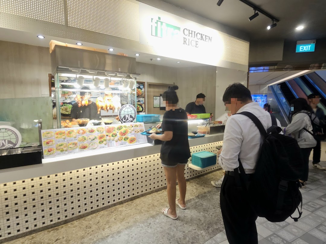 Customers order at a bustling Kopitiam food stall featuring roasted chicken and a variety of local dishes.