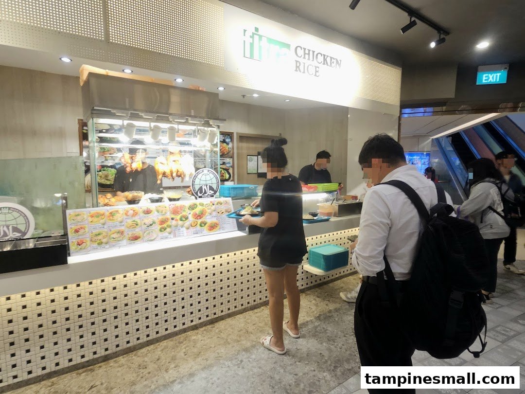 Customers order at a bustling Kopitiam food stall featuring roasted chicken and a variety of local dishes.