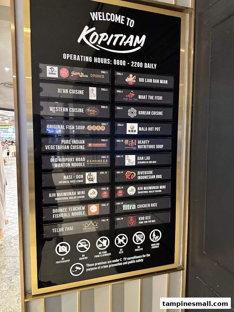 A large directory board at Kopitiam food court displaying operating hours and a diverse list of food stalls.