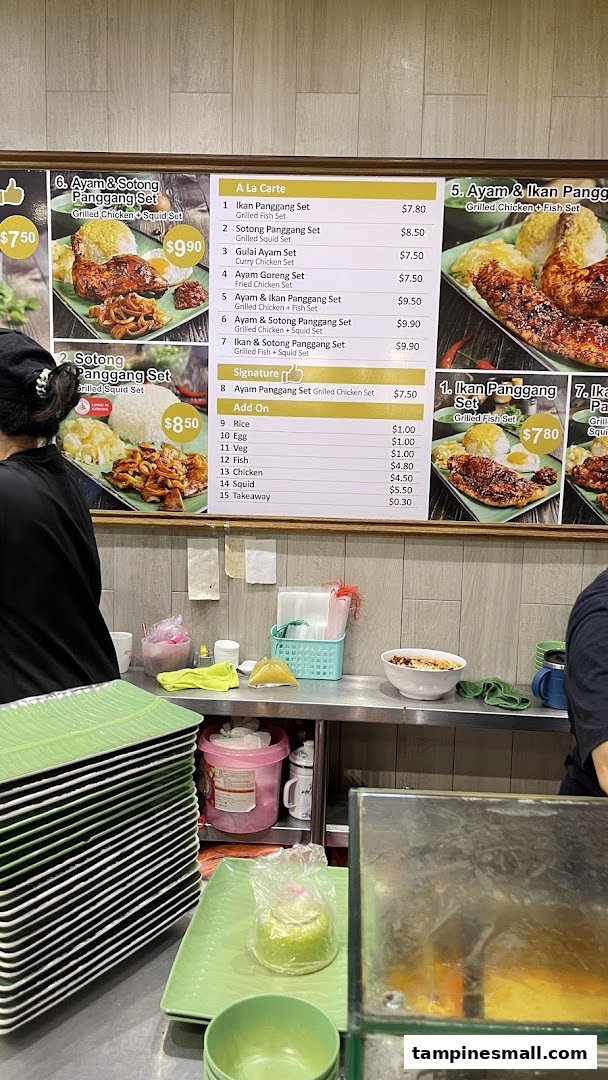 A food stall's menu board displays various set meals and add-ons, with a staff member in the foreground.