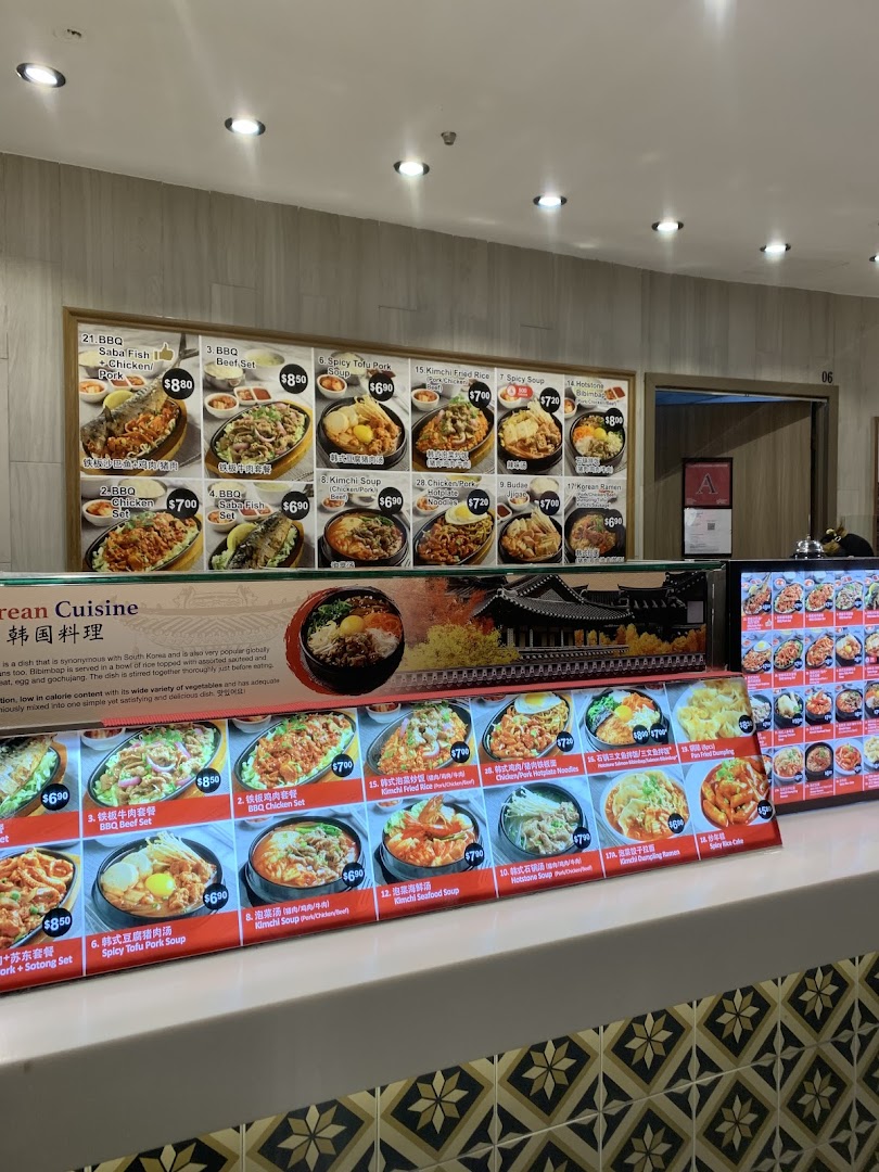 A vibrant display of menu boards showcasing various Korean dishes with images and prices at a food stall.