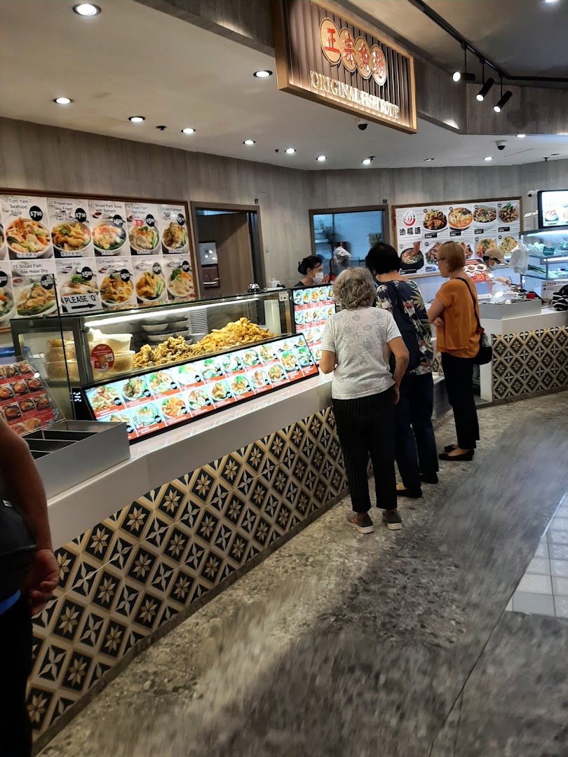 Customers queueing at Kopitiam's food counter with a variety of traditional dishes on display.