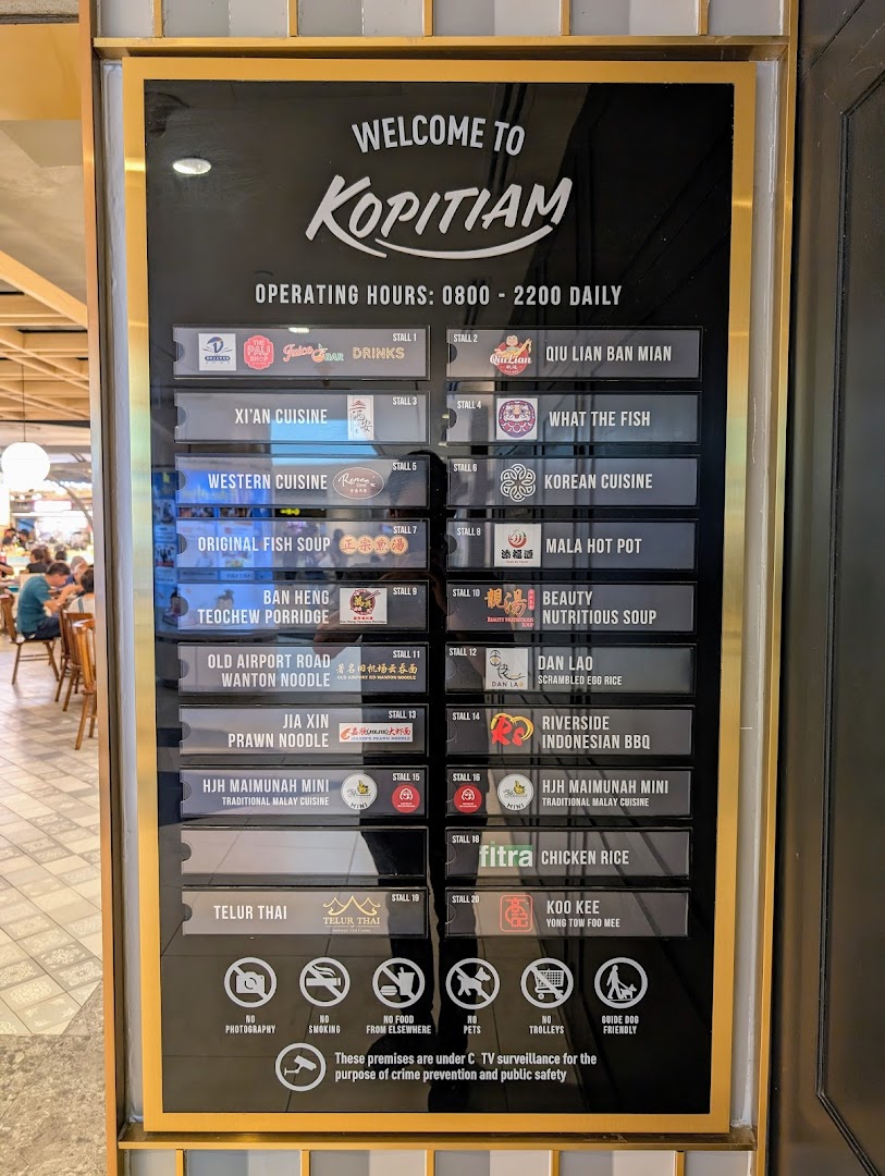 A large directory board displaying the various food stalls and operating hours within Kopitiam food court.