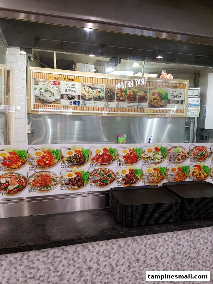 A vibrant display board showcasing various Asian dishes with prices at a Kopitiam food stall.