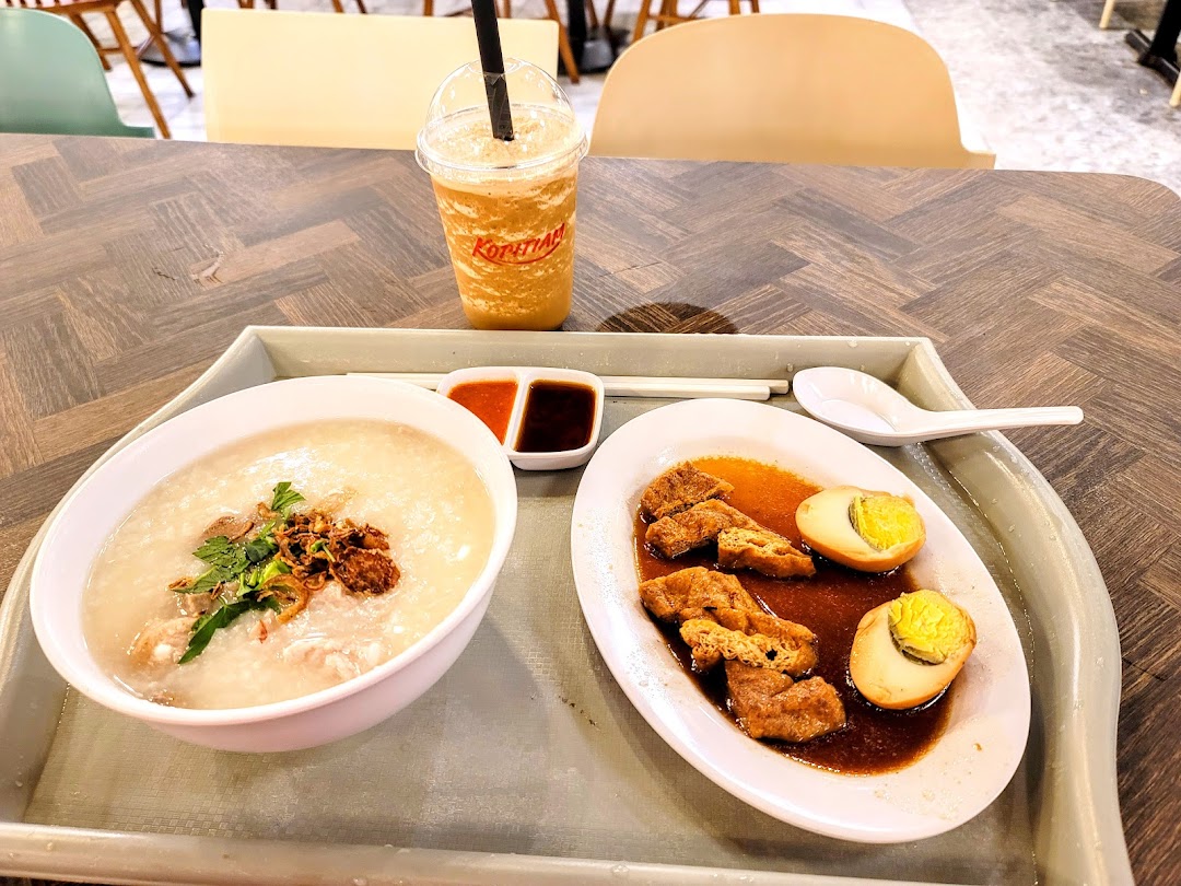 A delicious meal from Kopitiam featuring congee, braised tofu and eggs, and a refreshing drink.