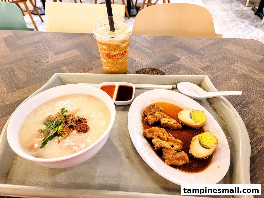 A delicious meal from Kopitiam featuring congee, braised tofu and eggs, and a refreshing drink.