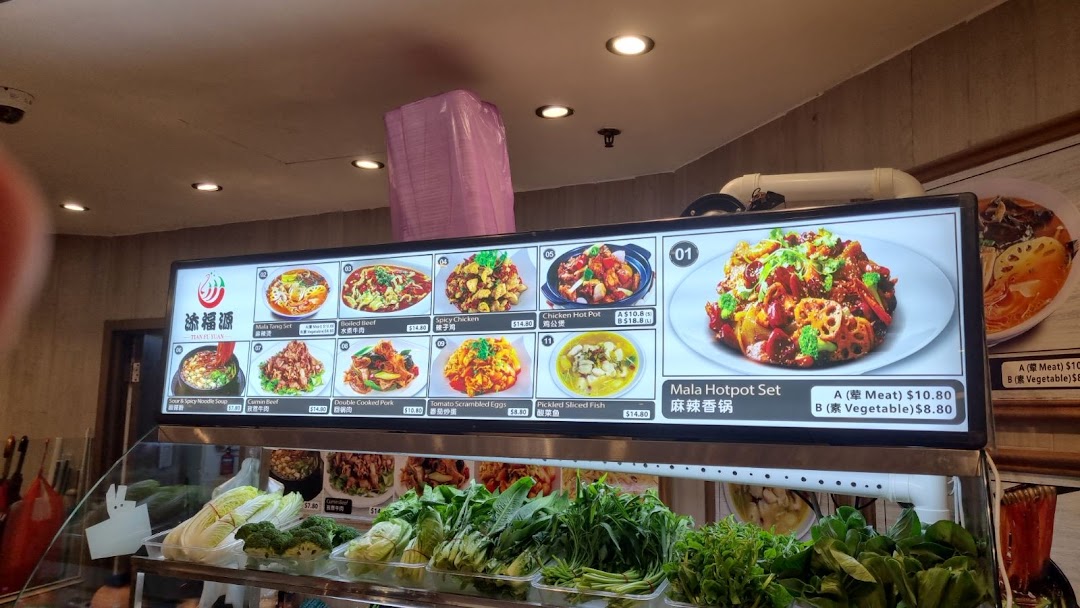 A bright menu board displaying various Chinese dishes and prices, with fresh vegetables in the foreground.