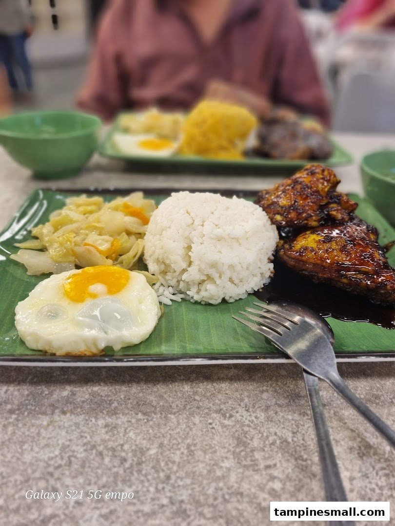 Close-up of two delicious Asian-style meals with rice, chicken, vegetables, and fried eggs.