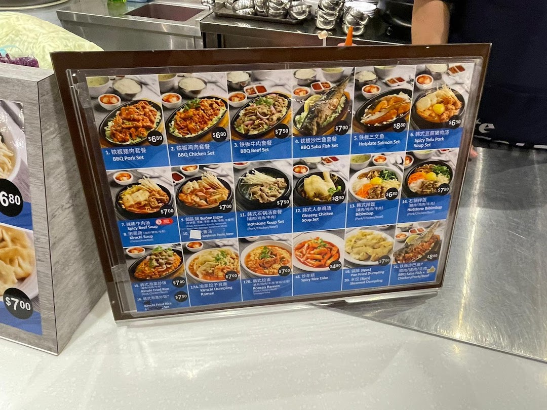A vibrant menu display showcasing a variety of Korean hotplate sets, soups, rice dishes, and noodles.