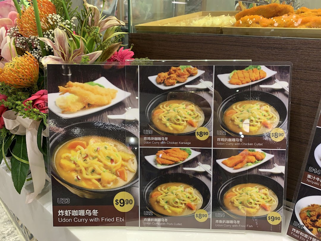 A display board showcasing various Udon Curry dishes with their prices and images at Kopitiam.