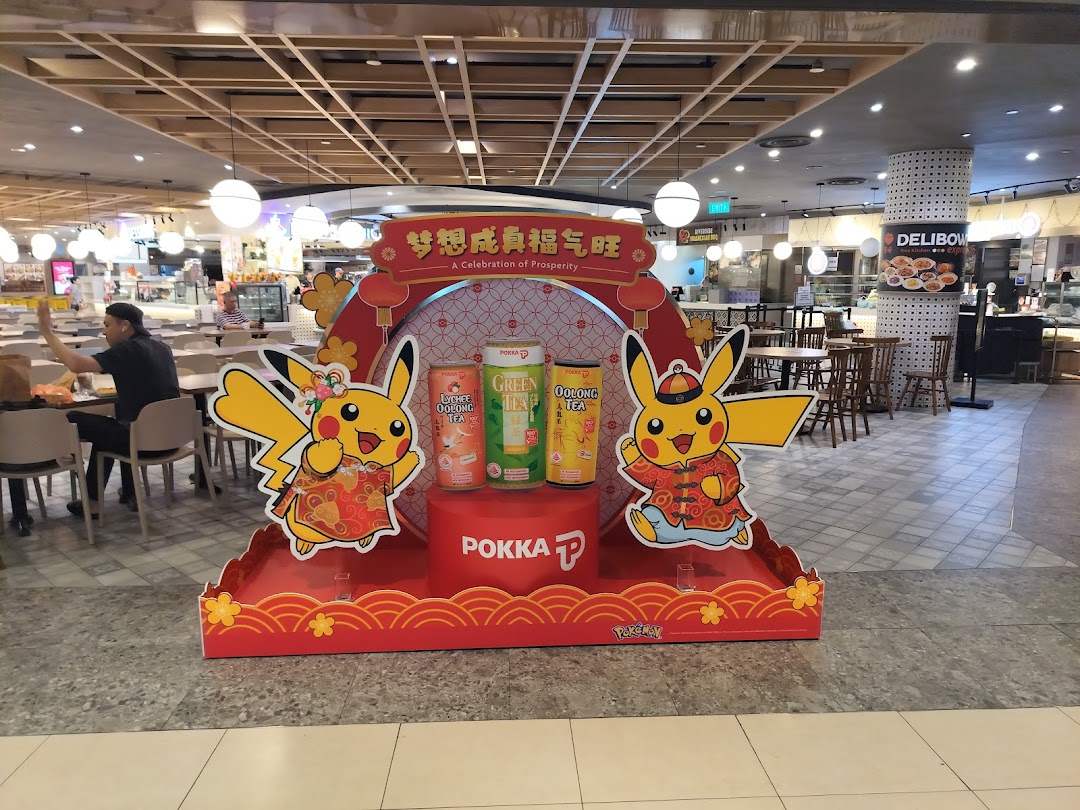 A large promotional display featuring Pikachu and Pokka drinks in a bustling food court setting.