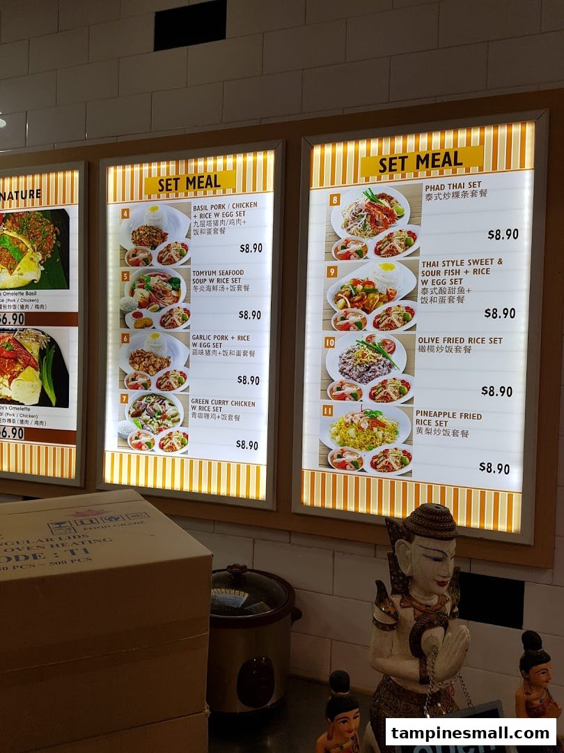 A brightly lit menu board displaying various Thai and Asian set meals with prices and images.