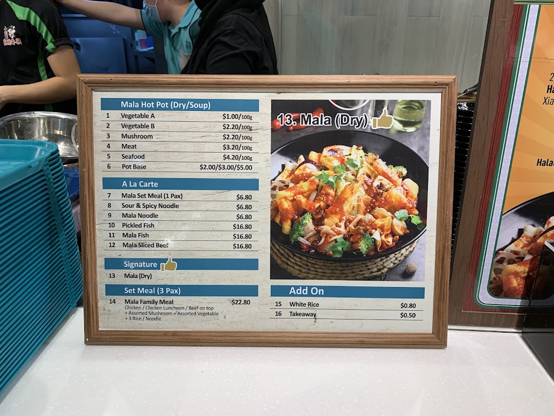 A framed menu board displaying various Mala hot pot and a la carte dishes with their prices and a featured image of Mala (Dry).