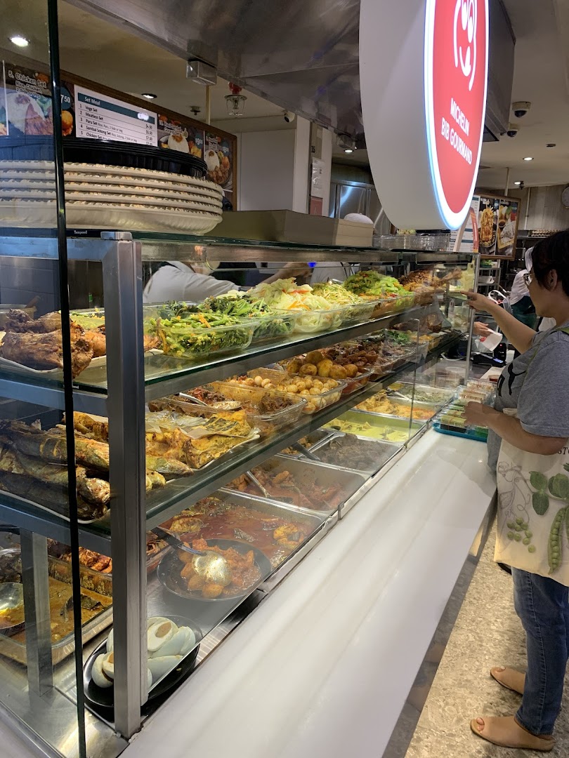 A bustling food stall showcasing a wide array of delicious Asian dishes in a display case.