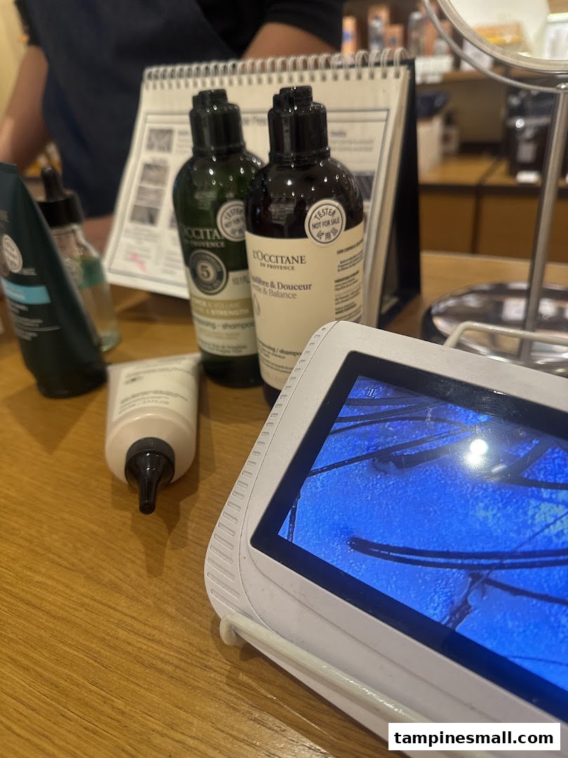 L'Occitane products and a hair/scalp analysis device on a counter, showcasing in-store services.