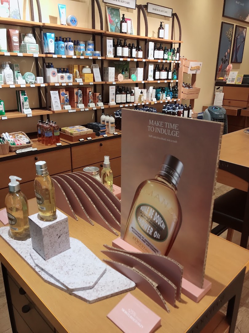An interior shot of L'Occitane, showcasing shelves filled with skincare products and a prominent display table.