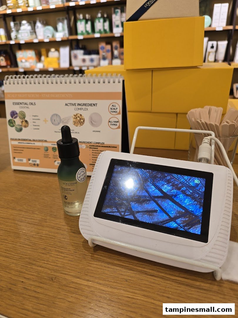 A L'Occitane display featuring a scalp analysis device, product, and information about scalp night serum.
