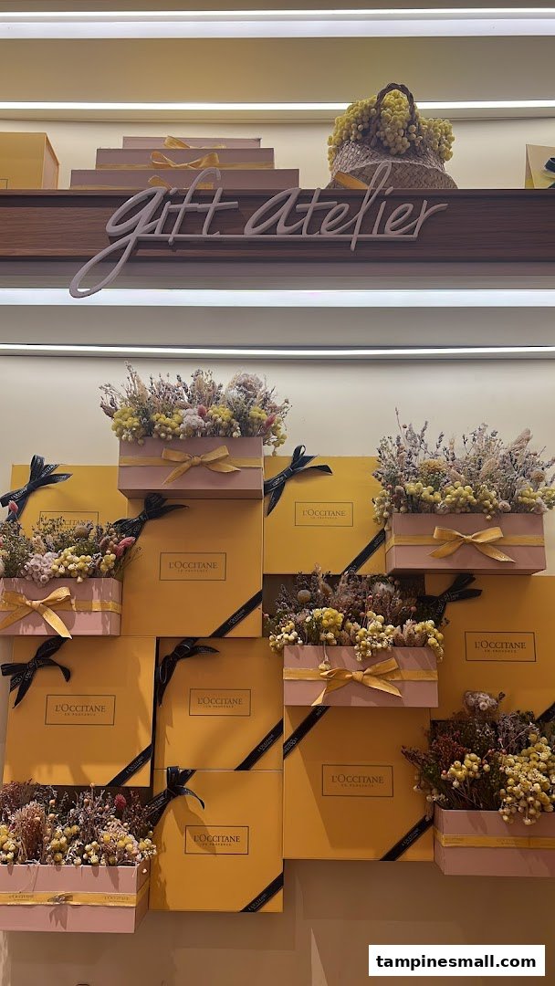 A vibrant display of L'Occitane gift boxes adorned with dried flowers, featuring a 'Gift Atelier' sign.