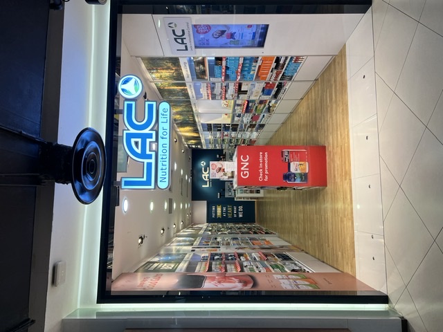 The image shows the brightly lit entrance of LAC Nutrition For Life, with shelves of products visible inside.