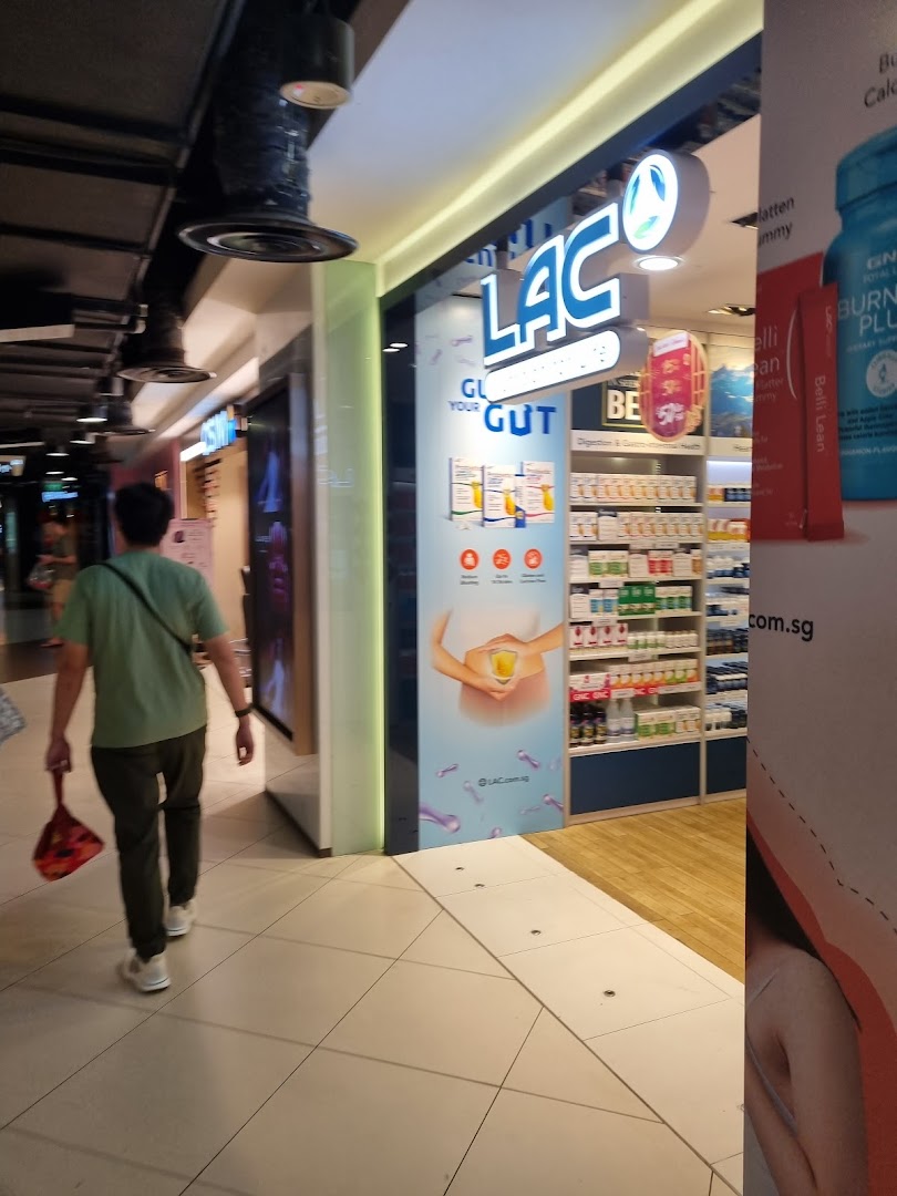 The brightly lit storefront of LAC Nutrition For Life, showcasing health products and a person walking by.