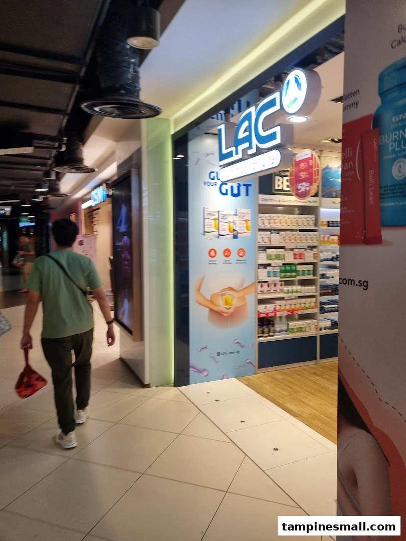 The brightly lit storefront of LAC Nutrition For Life, showcasing health products and a person walking by.