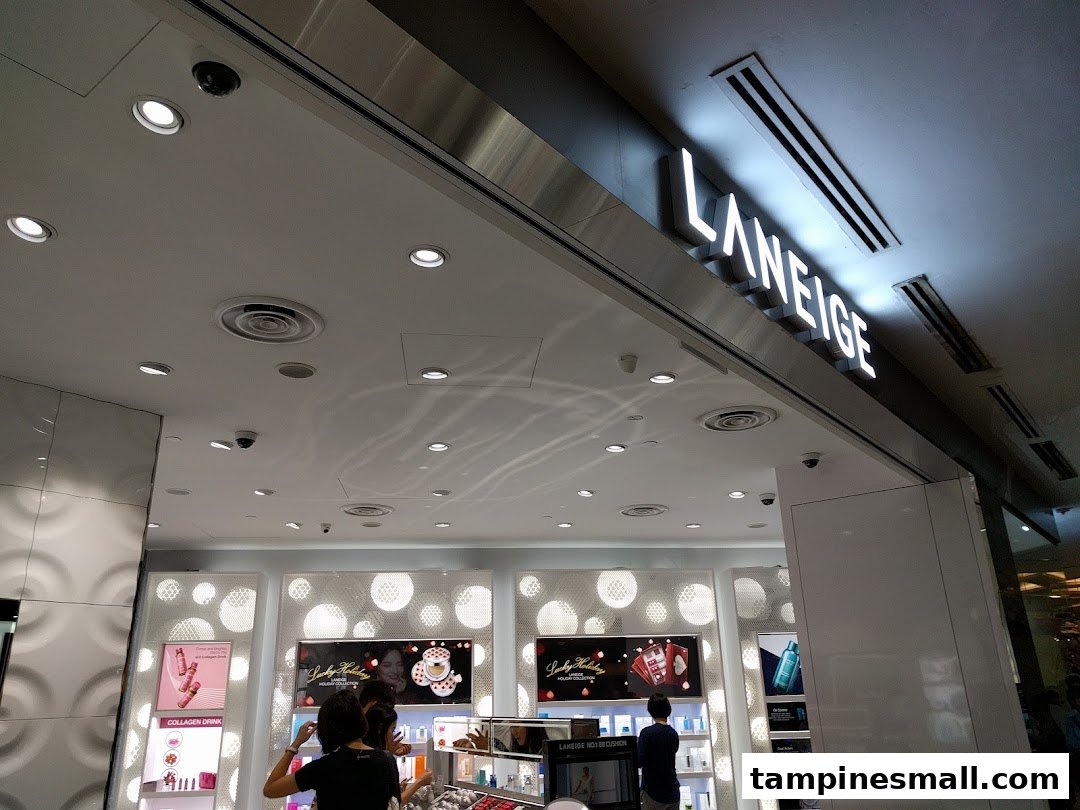 The illuminated Laneige sign above the entrance of a modern beauty store with customers inside.