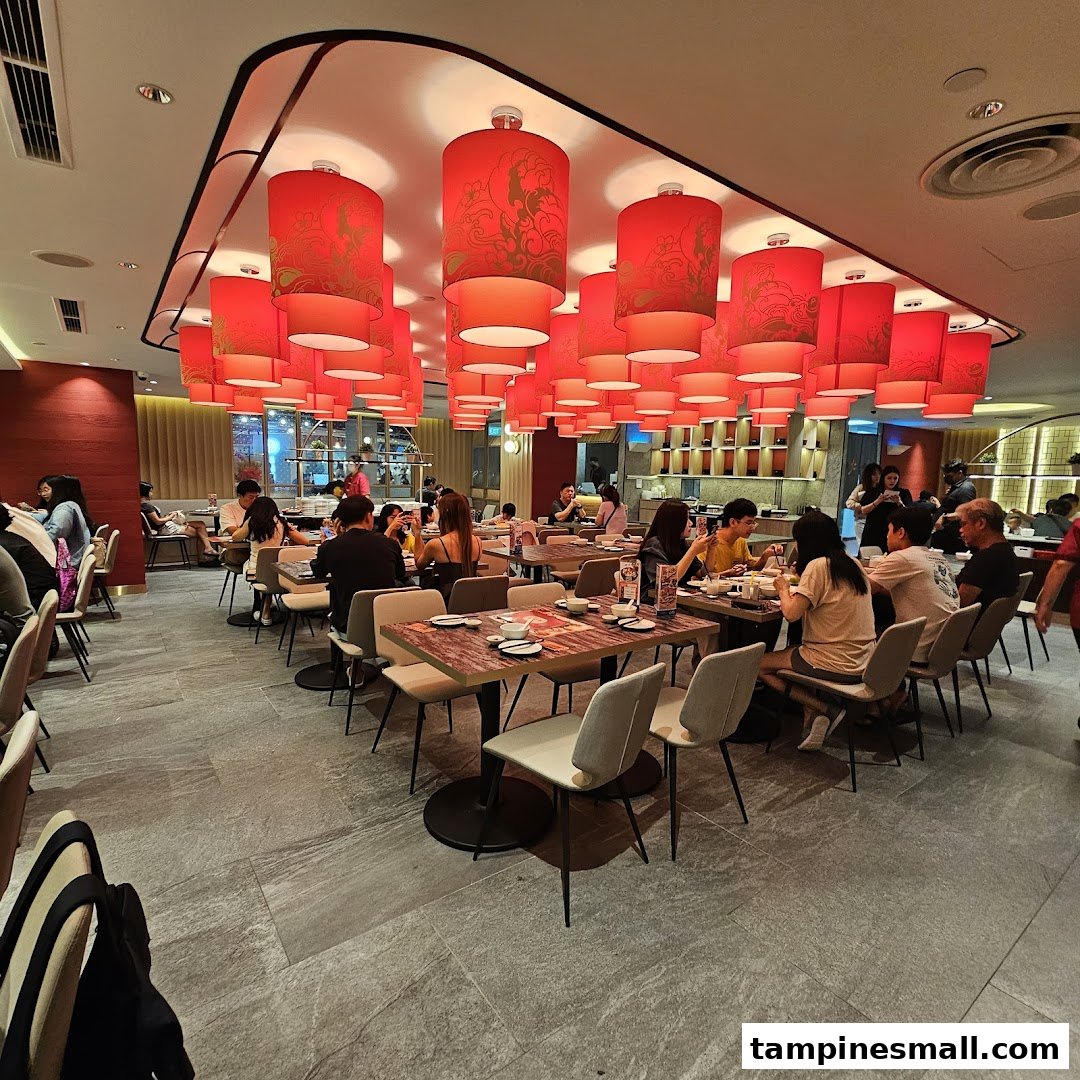 Diners enjoying a meal under vibrant red lanterns in a modern restaurant.